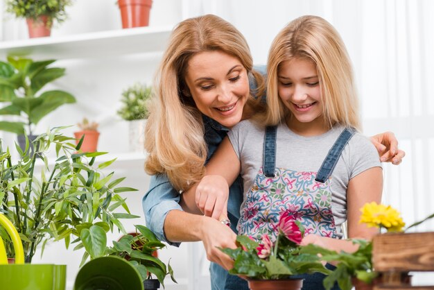 Mãe ensinando menina a plantar flores