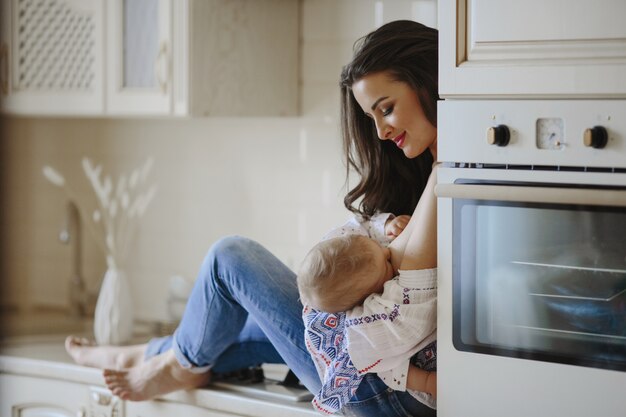 mãe está amamentando na cozinha