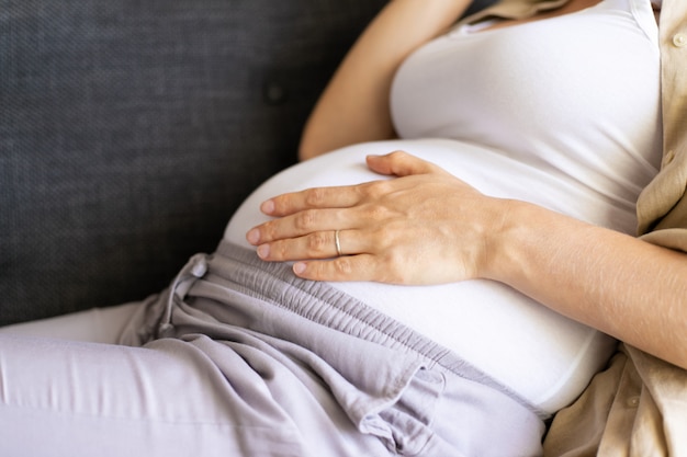 Mãe expectante que relaxa em casa