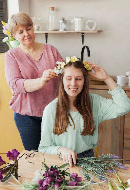 Mãe fazendo uma grinalda floral para filha