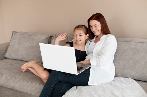 Mãe fazendo uma videochamada em família com a filha