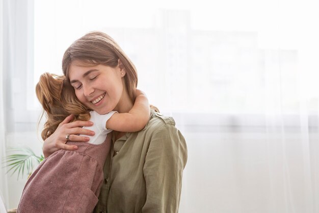 Mãe feliz, abraçando a filha