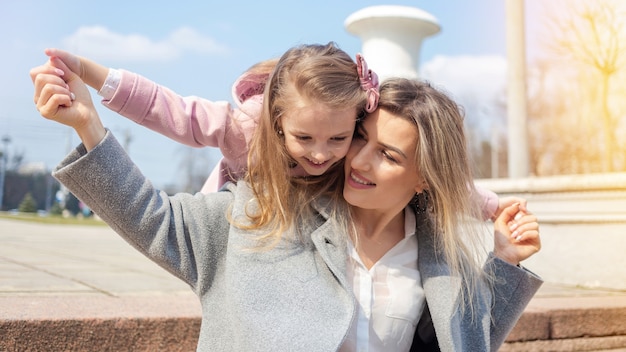 Foto grátis mãe feliz com filha posando ao ar livre