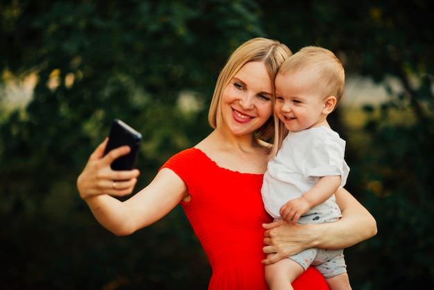 Mãe feliz e criança tomando uma selfie