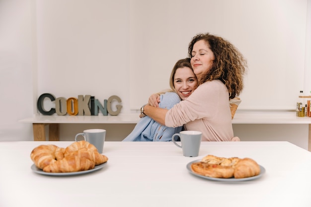 Mãe filha, abraçando, durante, pequeno almoço