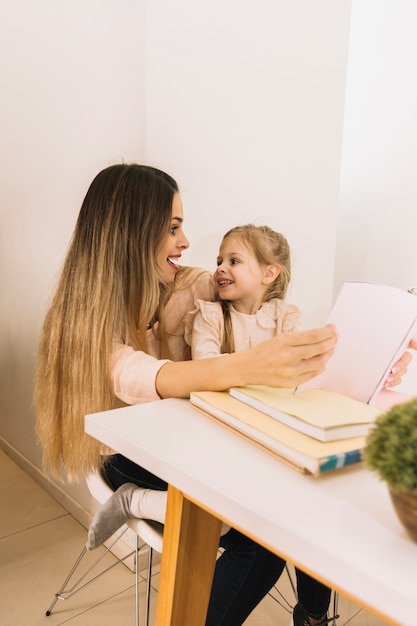 Mãe filha, com, livro, olhando um ao outro