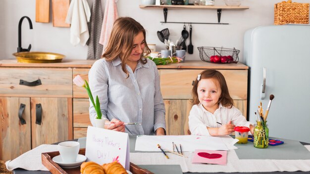 Mãe filha, com, pintar escovas, tabela