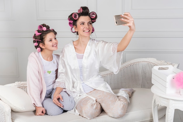 Mãe filha, em, curlers, levando, selfie