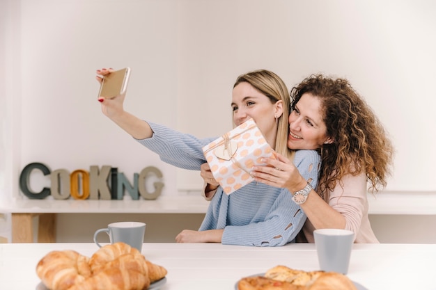 Mãe filha, posar, para, selfie, com, presente