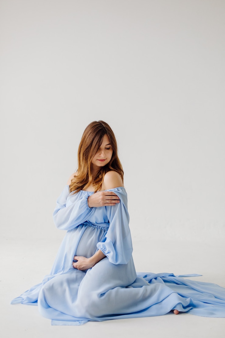 Foto grátis mãe grávida elegante em vestido posando orgulhosa de sua gravidez