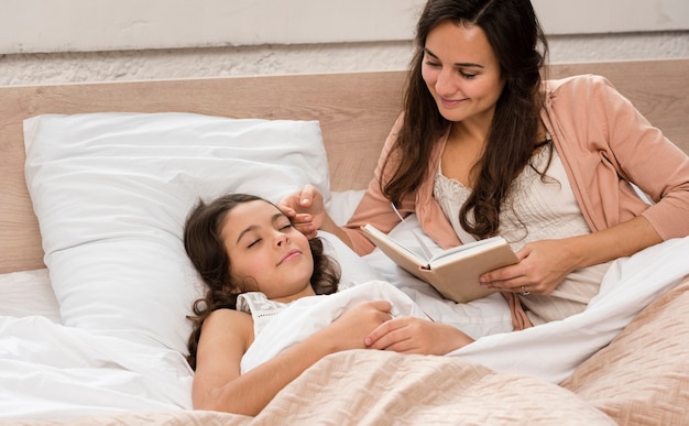 Mãe lendo um livro para sua filha