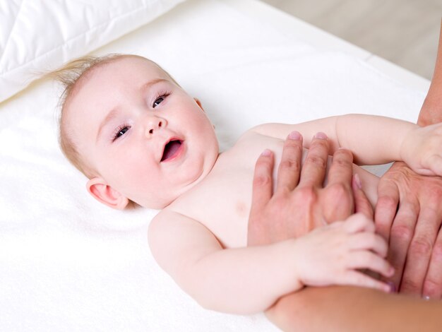 Mãe massageando bebê recém-nascido