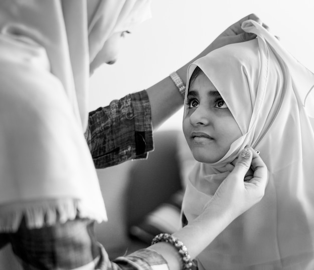 Foto grátis mãe muçulmana ensinando filha a usar um hijab