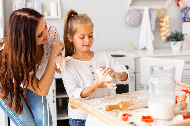 Mãe olhando para a filha cozinhar