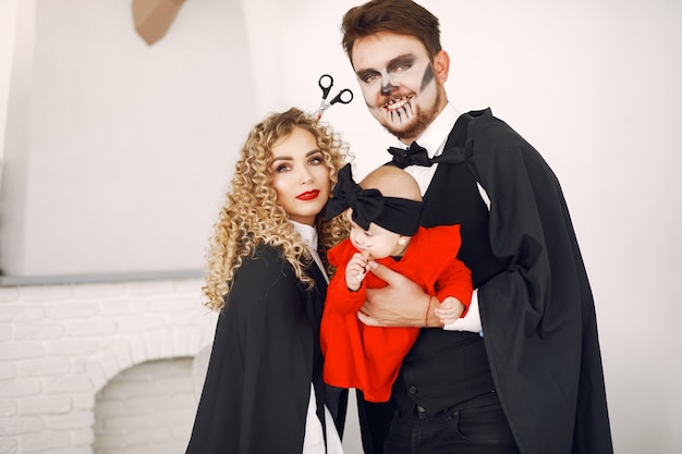 Mãe, pai e filhos em fantasias e maquiagem. família se prepara para a  celebração do halloween.