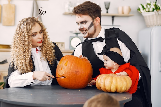 Mãe, pai e filhos em fantasias e maquiagem. família se prepara para a celebração do halloween.