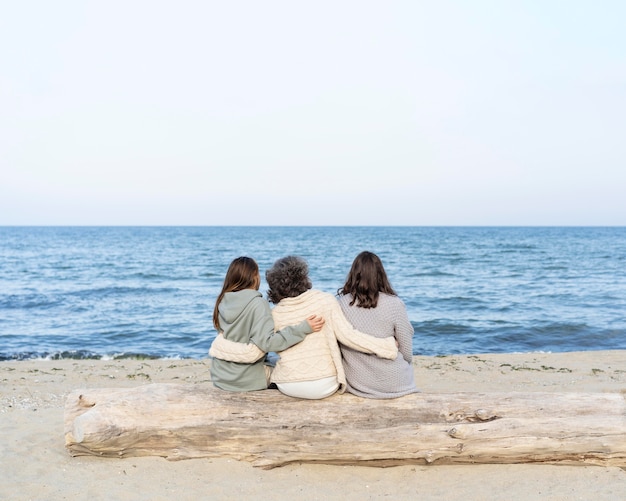 Mãe passando um tempo na praia com suas duas filhas