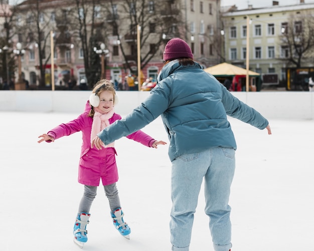 Mãe patinando no gelo com a filha