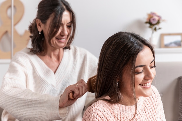 Mãe, penteando o cabelo da filha