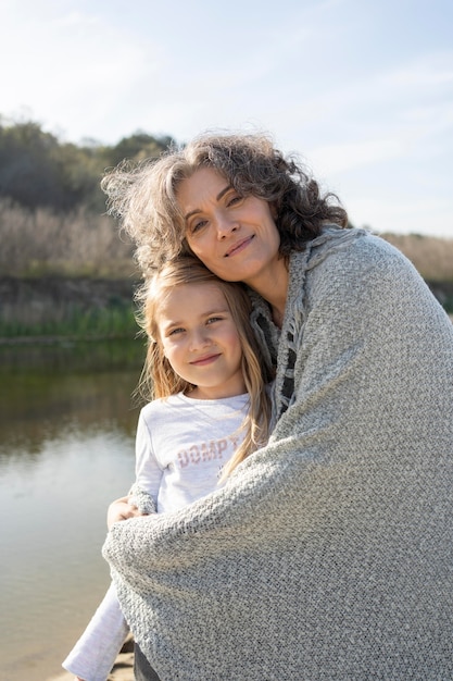 Mãe posando com sua filha ao ar livre