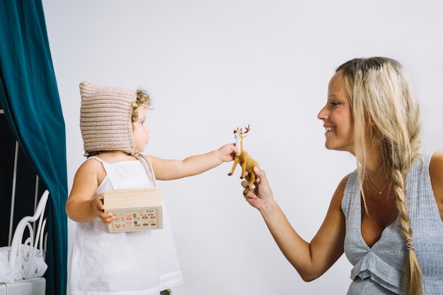 Foto grátis mãe que dá brinquedo de veado filha