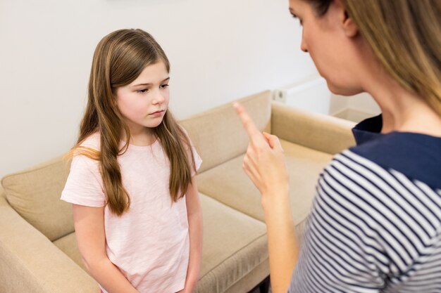 Mãe repreendendo a filha na sala de estar