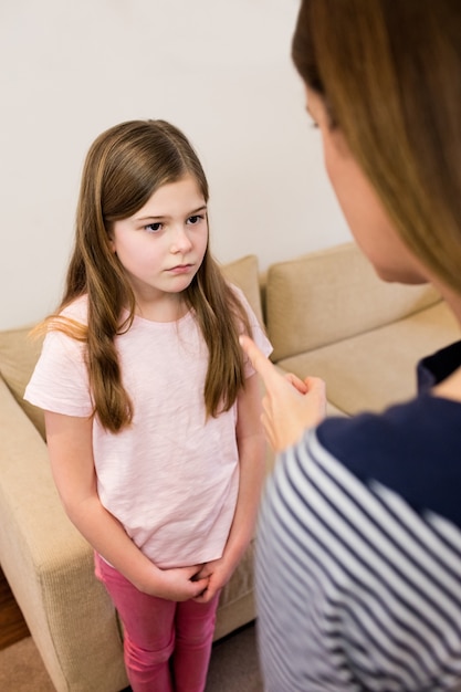 Mãe repreendendo a filha na sala de estar