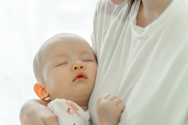 Mãe segurando bebê dormindo