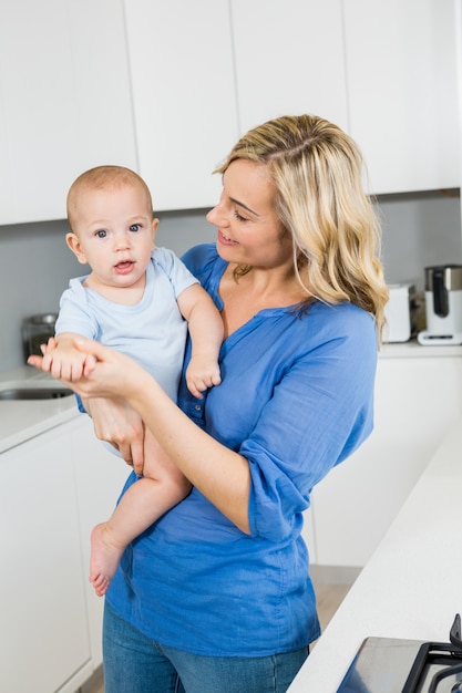 Mãe segurando seu bebê na cozinha