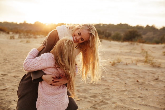 Mãe sorridente, brincando com sua filha