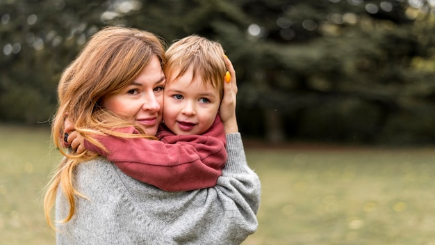 Foto grátis mãe sorridente segurando filho pequeno