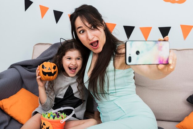 Mãe tomando uma selfie com a filha no dia das bruxas