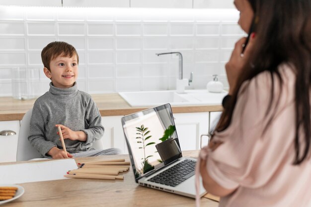 Mãe trabalhando com laptop de perto