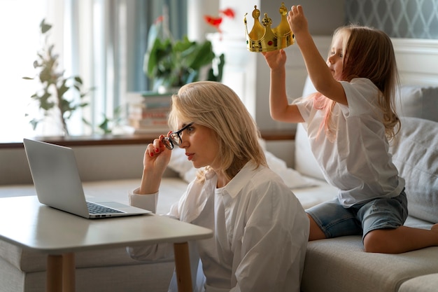 Foto grátis mãe trabalhando em casa tentando equilibrar a vida familiar com a criança e o trabalho