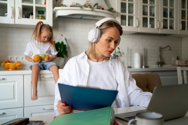 Mãe trabalhando em casa tentando equilibrar a vida familiar com a criança e o trabalho