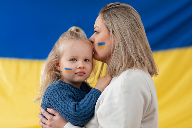 Mãe ucraniana de tiro médio beijando criança