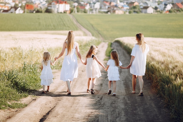 Mães com filhas brincando em um campo de outono