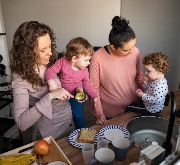 Mães LGBT em casa passando um tempo na cozinha com seus filhos