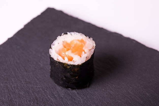 Foto grátis makisushi roll mentira na placa de cerâmica preta