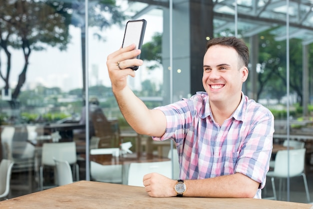Man Taking Selfie no Smartphone no Outdoor Cafe