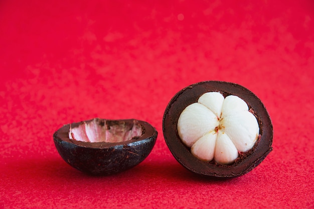 Foto grátis mangosteen frutas tailandesas populares - uma fruta tropical com segmentos brancos suculentos doces de carne dentro de uma espessa casca marrom-avermelhada.