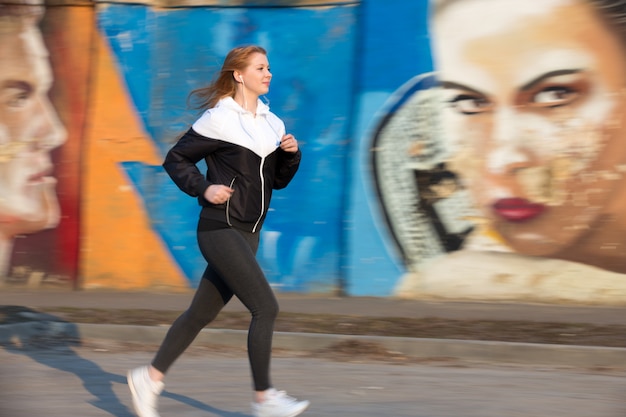 Foto grátis manhã corrida ao lado da parede de graffiti