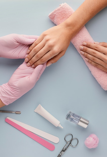 Manicure segurando a mão do cliente Foto gratuita