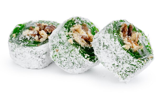Manjar turco verde com nozes no açúcar de confeiteiro isolado no branco