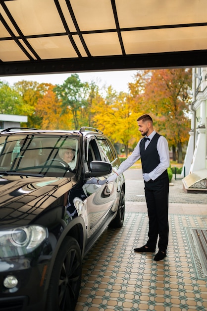 Foto grátis manobrista cuidando do veículo do cliente