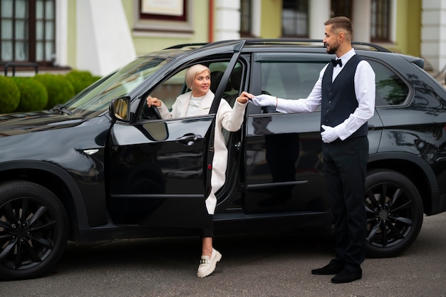 Manobrista de estacionamento em seu trabalho com veículo e mulher