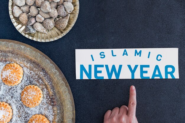 Mão apontando para o ano novo islâmico em sobremesas