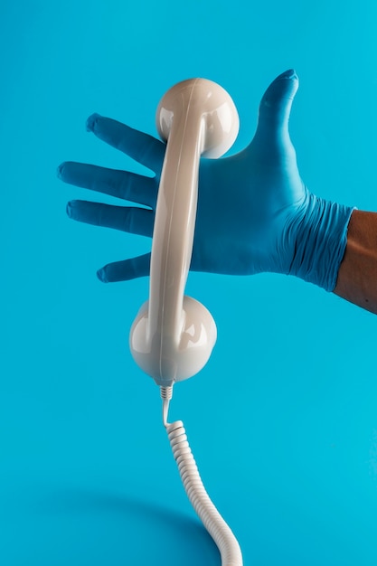 Mão com luva segurando o receptor do telefone