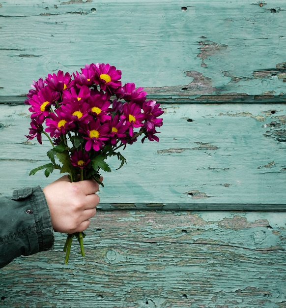 Foto grátis mão de alto ângulo com flores da primavera