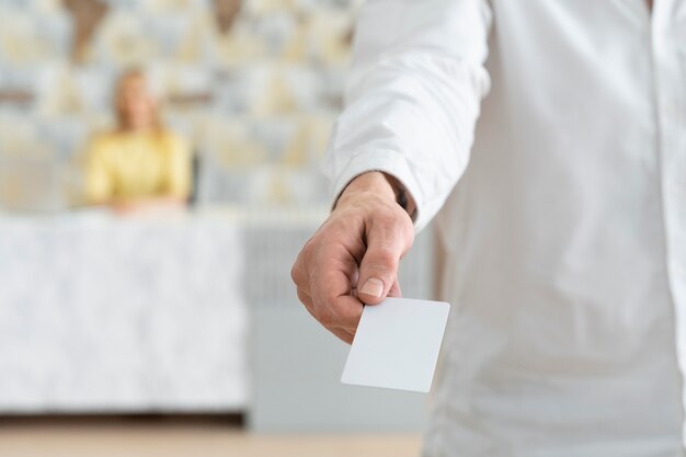 Mão de alto ângulo segurando o cartão de visita em branco